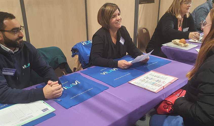 Deux collaborateurs du groupe VILAVI discutant avec une jeune femme